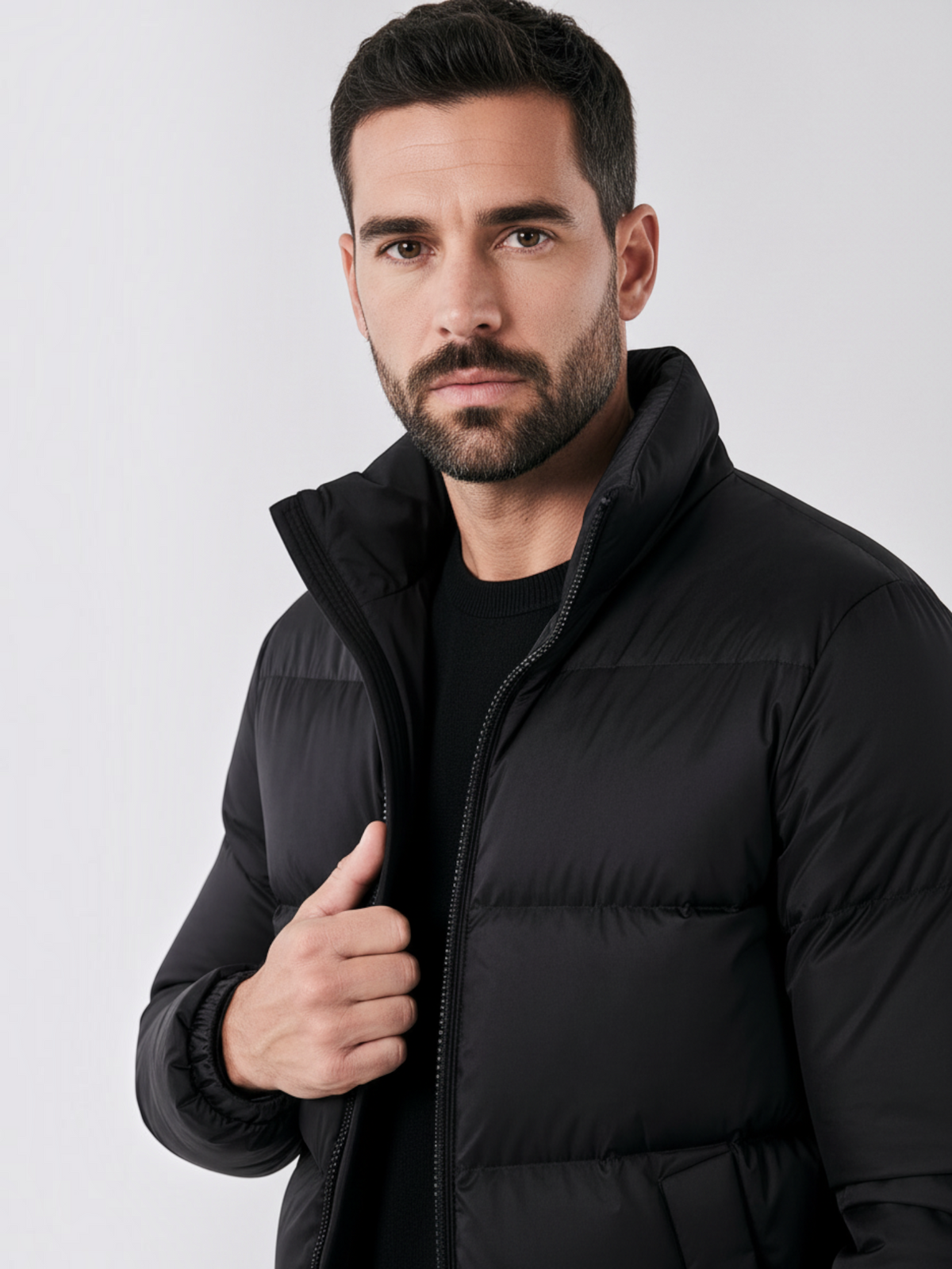 Homem vestindo jaqueta puffer preta Habitat Masculino com gola alta e fechamento em zíper, estilo casual e elegante.