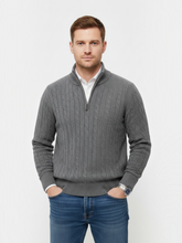 Homem vestindo suéter cinza Habitat Masculino com zíper, gola alta e textura trançada sobre camisa branca e jeans.