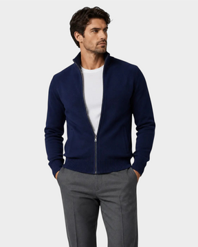 Homem vestindo cardigan azul marinho com zíper da marca Habitat Masculino sobre camiseta branca e calça cinza