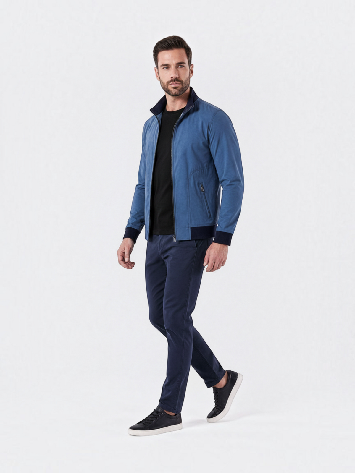 Modelo veste jaqueta bomber azul Habitat Masculino com forro xadrez, zíper frontal e punhos de ribana em fundo branco.