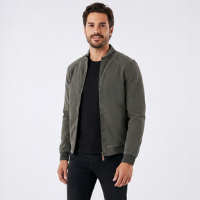Homem vestindo jaqueta bomber Habitat Masculino verde com gola banda, mangas raglan e fechamento em zíper.