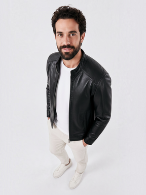 Homem vestindo jaqueta preta de couro PU Habitat Masculino com camiseta branca e calça clara em fundo neutro