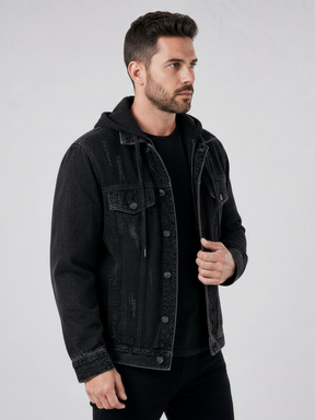 Modelo veste jaqueta jeans preta Habitat Masculino estilo trucker com capuz, lavagem desgastada e detalhes rasgados.