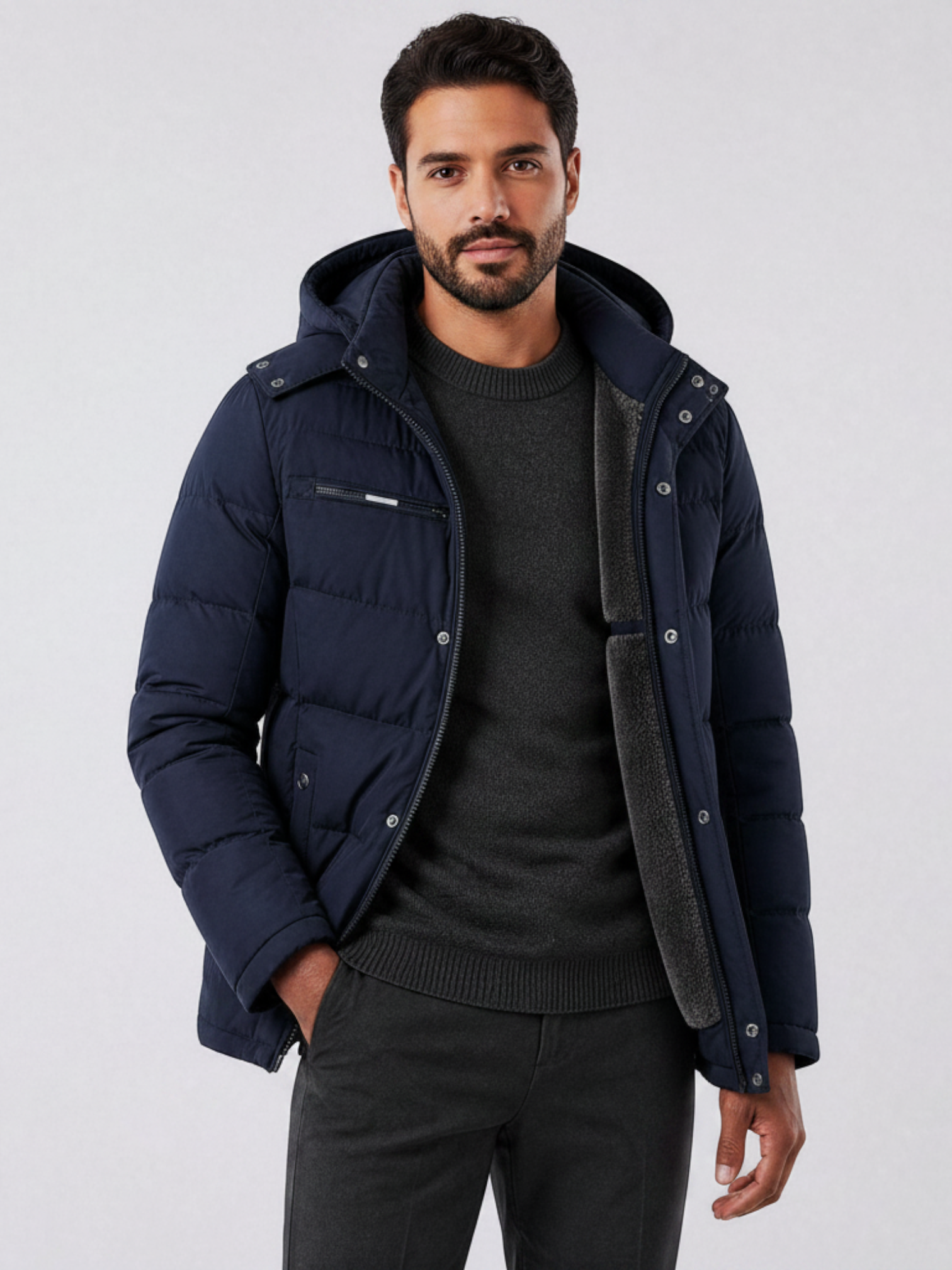 Homem vestindo jaqueta puffer azul marinho Habitat Masculino com forro de lã, capuz removível e bolsos com zíper.