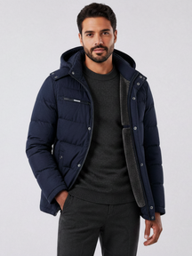 Homem vestindo jaqueta puffer azul marinho Habitat Masculino com forro de lã, capuz removível e bolsos com zíper.