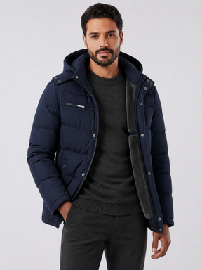 Homem vestindo jaqueta puffer azul marinho Habitat Masculino com forro de lã, capuz removível e bolsos com zíper.