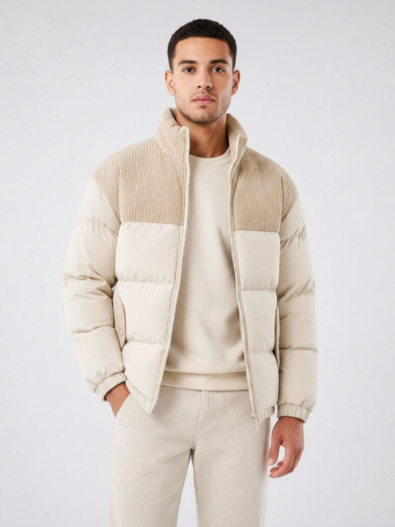 Homem vestindo jaqueta puffer Habitat Masculino bege com gola alta estruturada e detalhes em textura canelada
