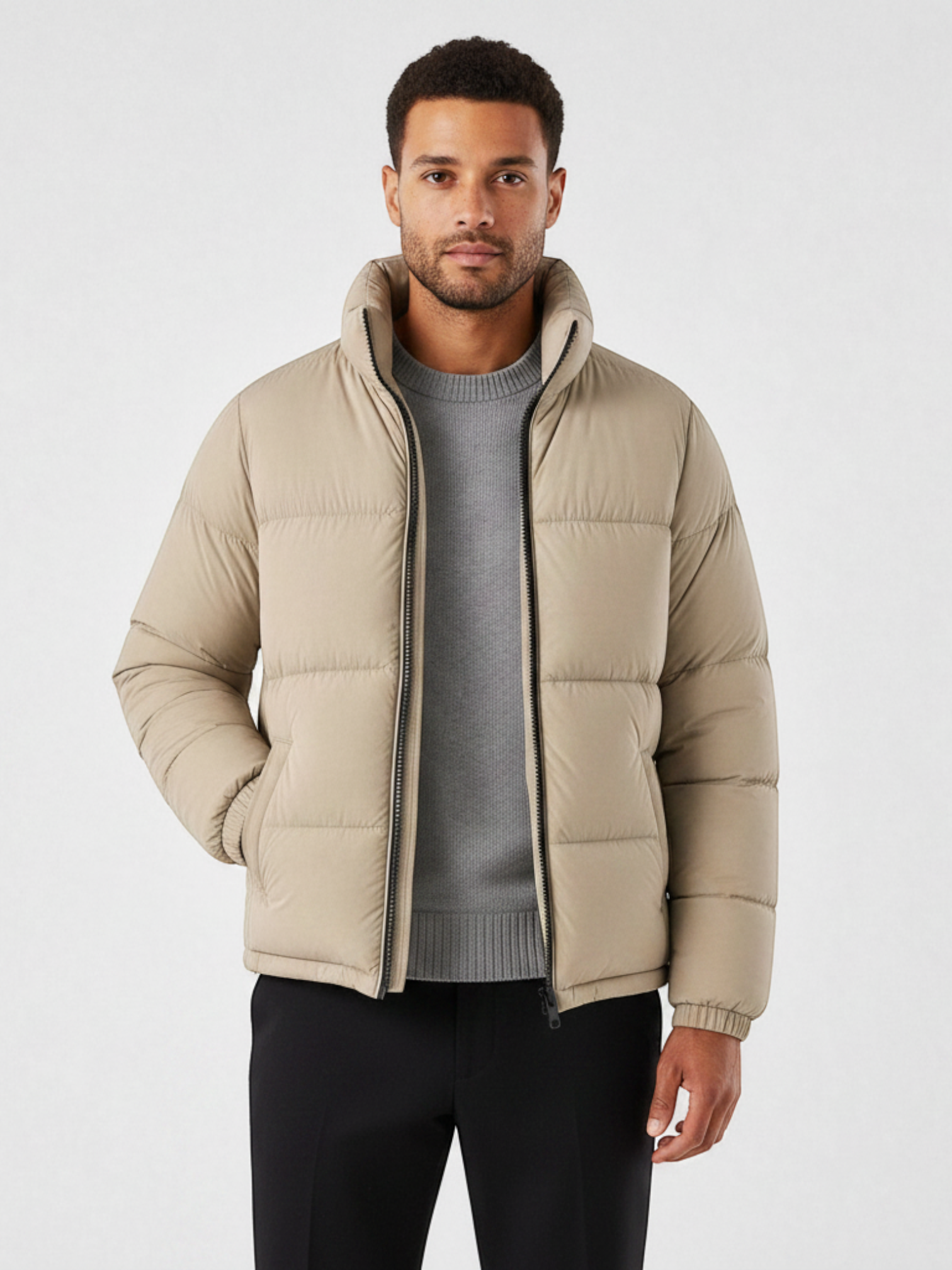 Homem vestindo jaqueta puffer cáqui Habitat Masculino com gola alta, zíper frontal e bolsos impermeáveis.
