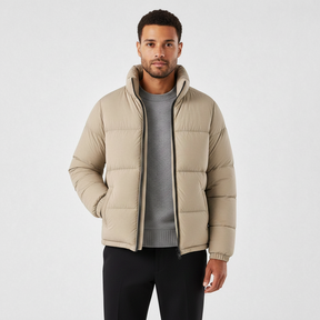 Homem vestindo jaqueta puffer cáqui Habitat Masculino com gola alta, zíper frontal e bolsos impermeáveis.