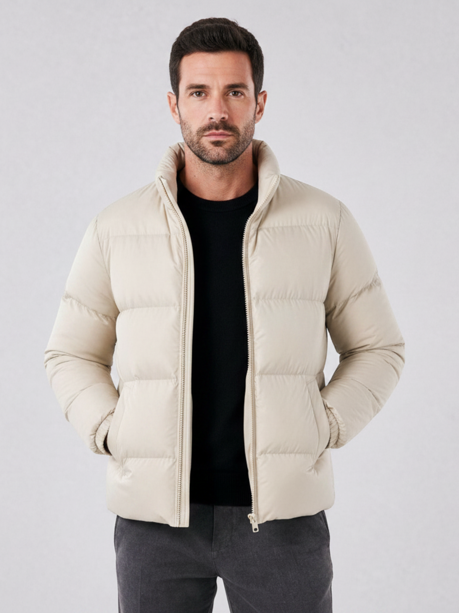 Modelo vestindo jaqueta puffer cáqui Habitat Masculino com gola alta, zíper e forro impermeável sobre malha preta.