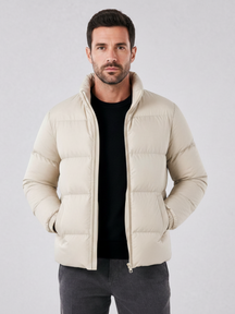 Modelo vestindo jaqueta puffer cáqui Habitat Masculino com gola alta, zíper e forro impermeável sobre malha preta.