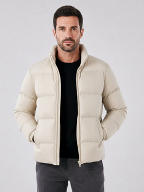 Modelo vestindo jaqueta puffer cáqui Habitat Masculino com gola alta, zíper e forro impermeável sobre malha preta.