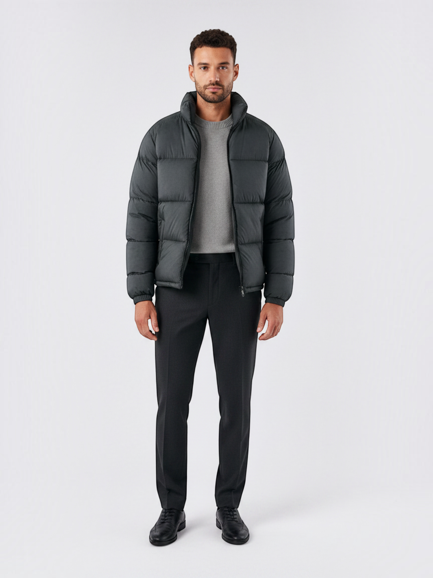 Modelo vestindo jaqueta puffer cinza escuro Habitat Masculino com gola alta, zíper e bolsos impermeáveis.