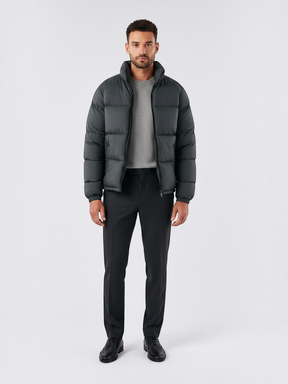 Modelo vestindo jaqueta puffer cinza escuro Habitat Masculino com gola alta, zíper e bolsos impermeáveis.