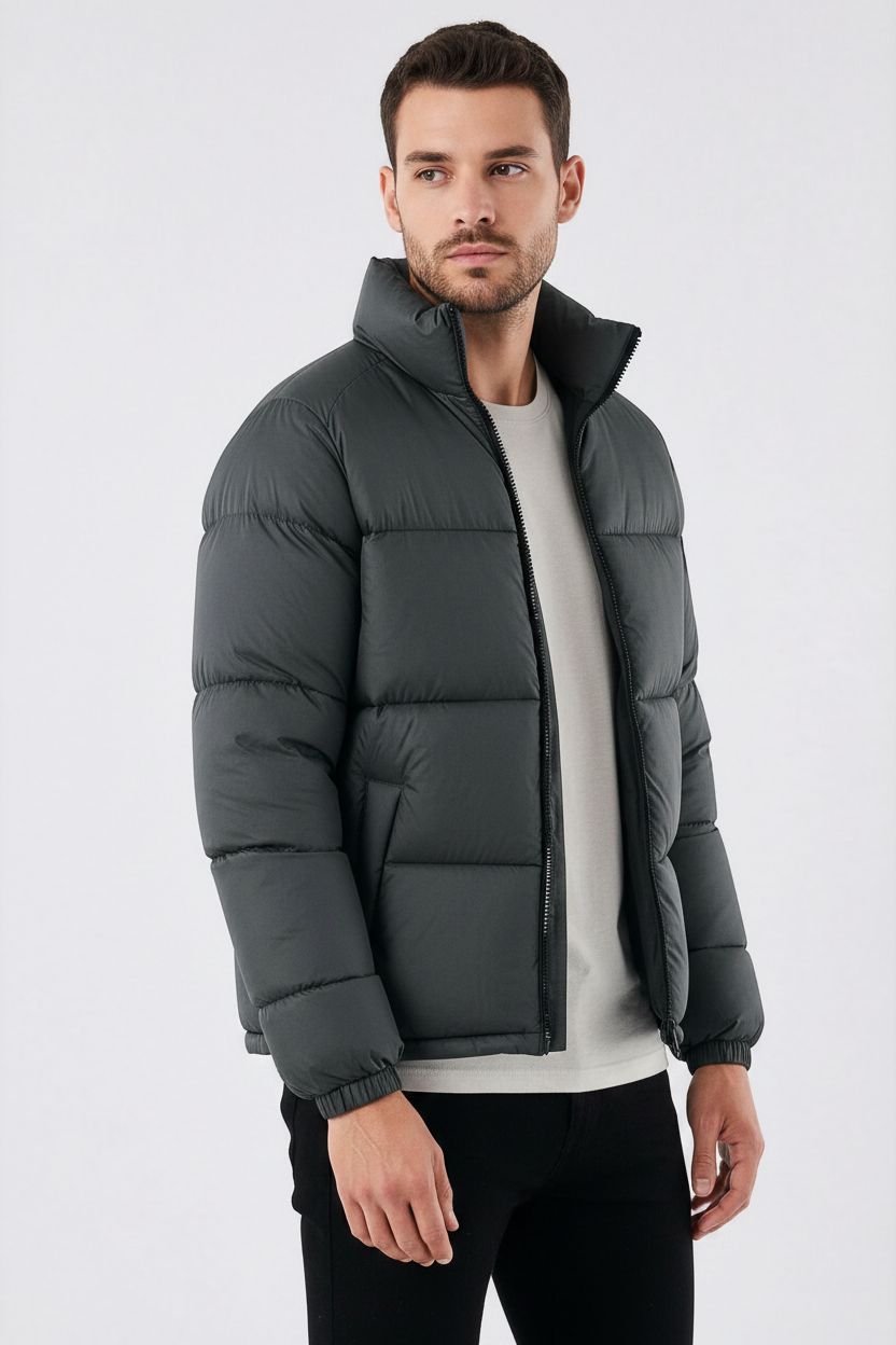 Homem vestindo jaqueta puffer cinza escuro Habitat Masculino com gola alta, zíper frontal e bolsos impermeáveis.