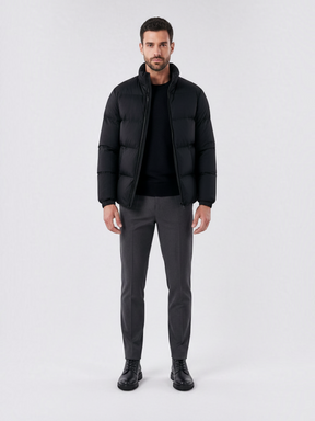 Modelo vestindo jaqueta puffer preta Habitat Masculino com gola alta, zíper e forro impermeável em fundo neutro.