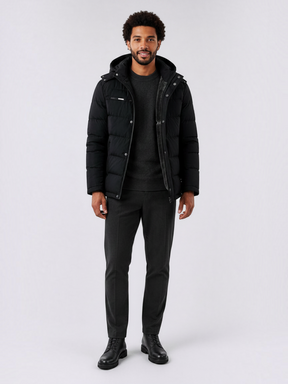 Modelo veste jaqueta puffer preta Habitat Masculino com capuz removível, forro de lã e zíper, sobre suéter e calça social.