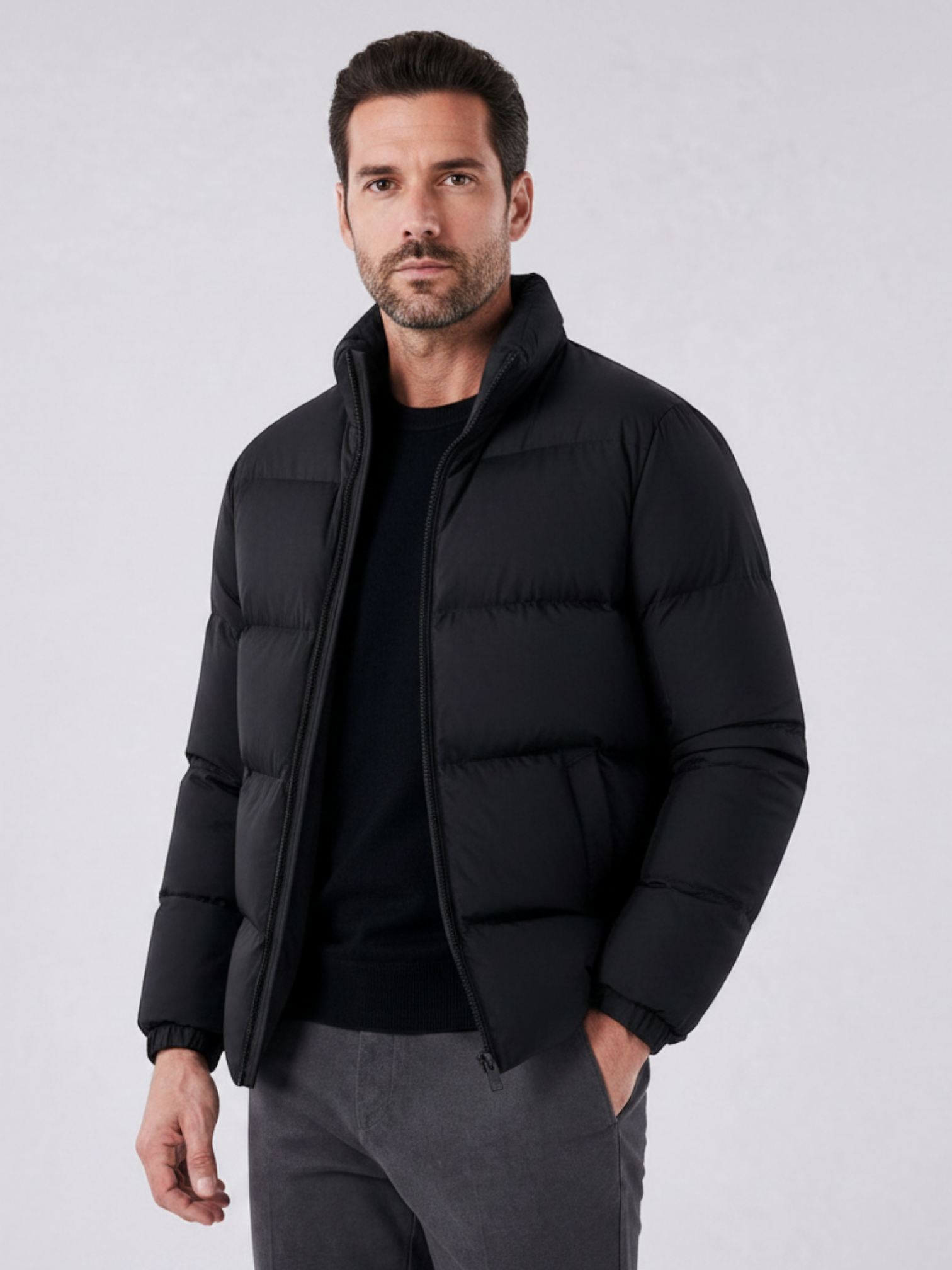 Homem vestindo jaqueta puffer preta Habitat Masculino com gola alta e zíper, ideal para dias frios.