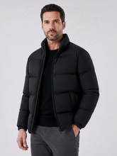 Homem vestindo jaqueta puffer preta Habitat Masculino com gola alta e zíper, ideal para dias frios.