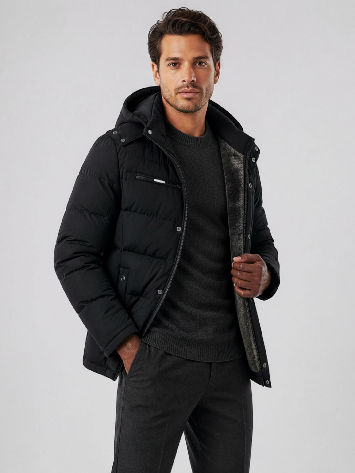 Homem vestindo jaqueta puffer preta Habitat Masculino com capuz removível e forro de lã, ideal para inverno intenso.