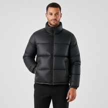 Modelo vestindo jaqueta puffer preta Habitat Masculino com gola alta, zíper frontal e bolsos impermeáveis.