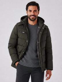 Modelo veste jaqueta puffer verde Habitat Masculino com capuz removível, forro de lã e bolsos com zíper.