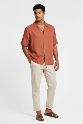 Sandália Habitat Masculino Naxos caramelo em couro com tiras entrelaçadas usada por modelo com camisa e calça de linho