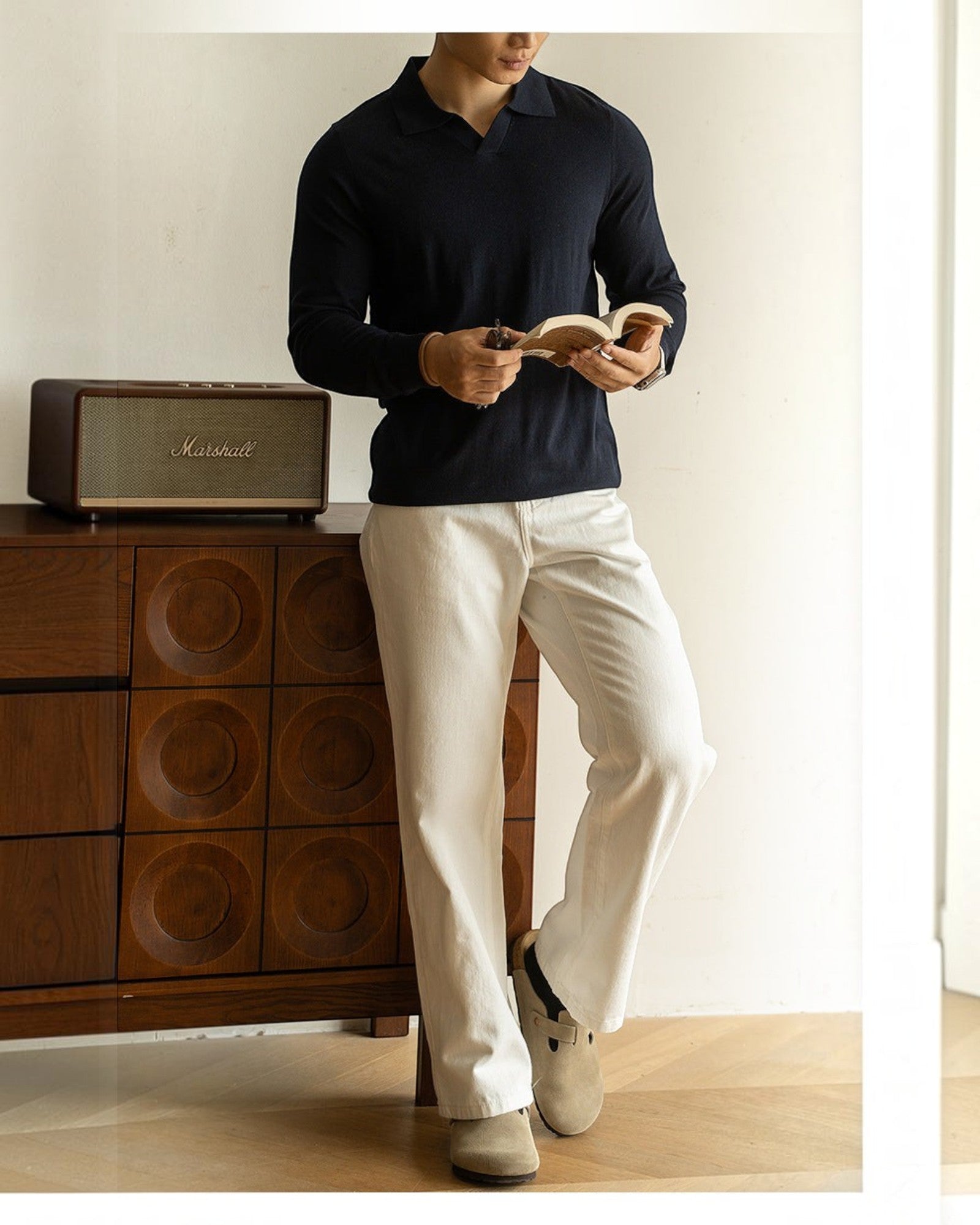 Homem vestindo suéter Habitat Masculino Cortina azul marinho com gola polo, combinado com calça clara e sapatos bege.