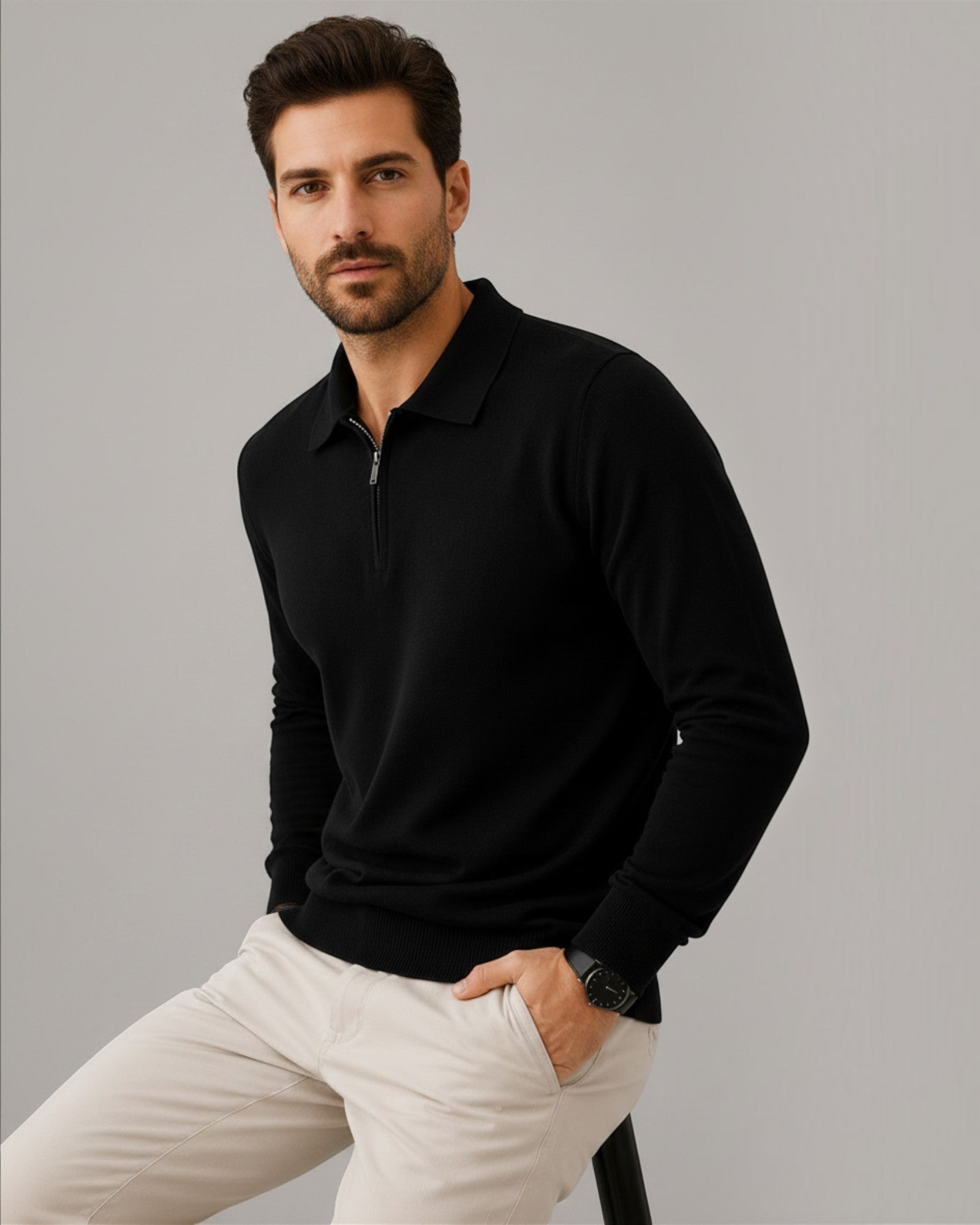 Homem vestindo suéter preto de lã Habitat Masculino com zíper no colarinho e calça clara em fundo neutro
